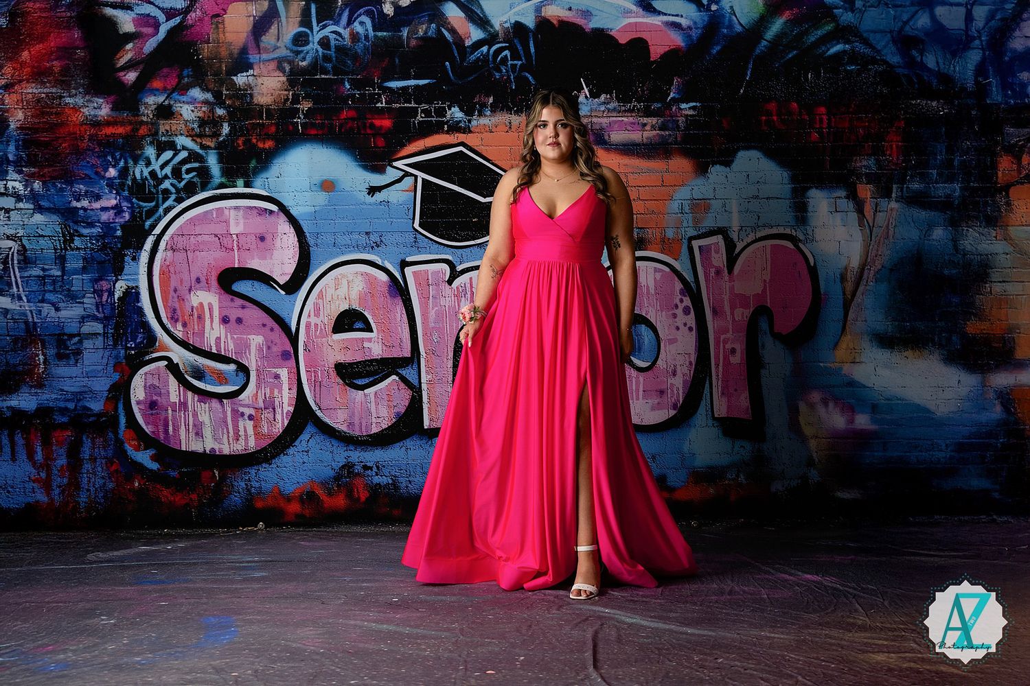 Vibrant pink maxi dress photographed against colorful graffiti wall with 'Senior' text.