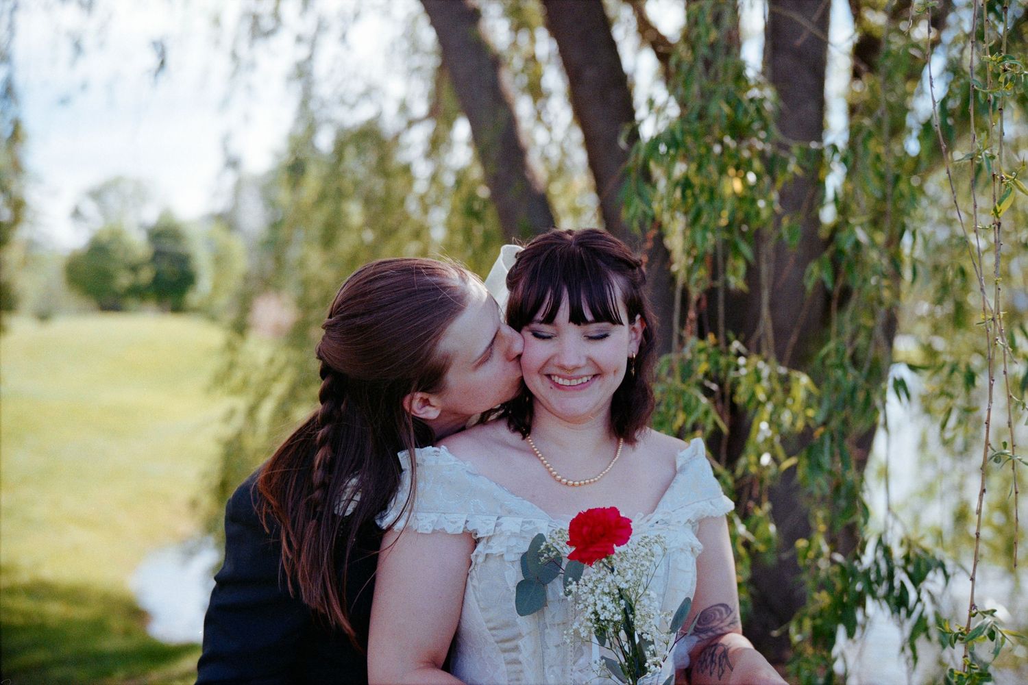 A romantic close up photo of a couple about to kiss at their wedding outdoors.