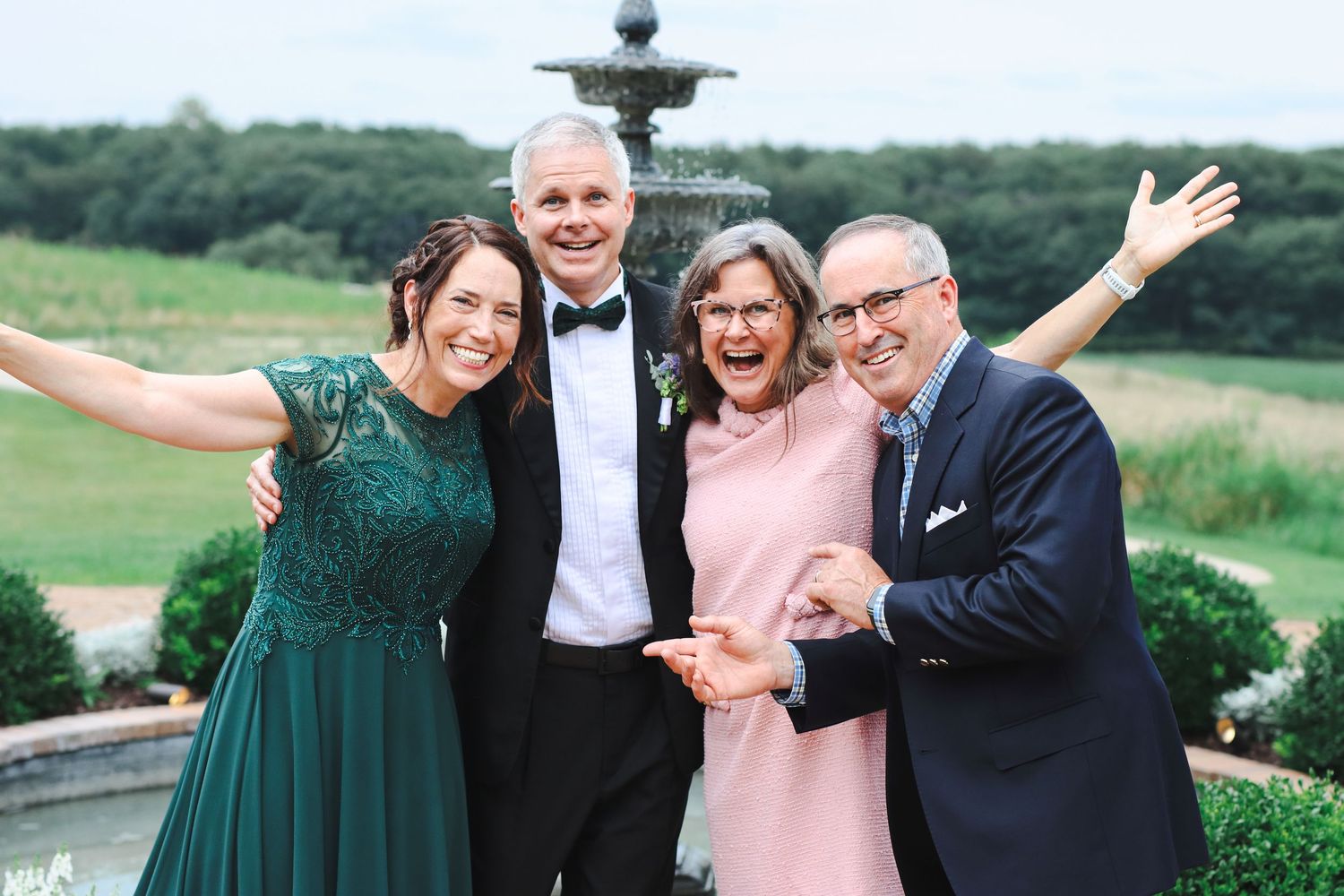 Wedding photo of parents of bride and groom in front of fountain