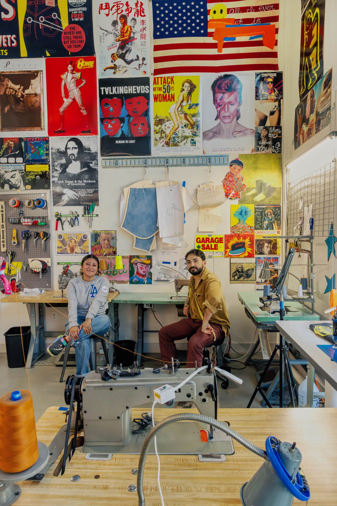 Sewing workshop interior with colorful posters on walls and multiple sewing machines.