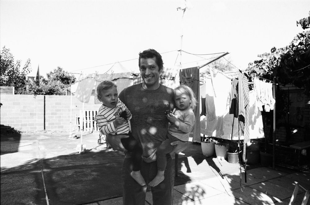 Warm family lifestyle photos in Perth, featuring twins, mum, and dad in a natural home setting.