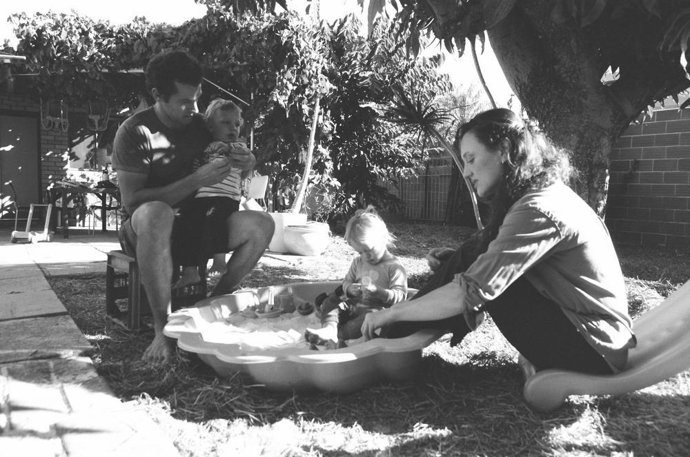 Heartfelt in-home family session in Perth, highlighting connection and play between parents and twins.