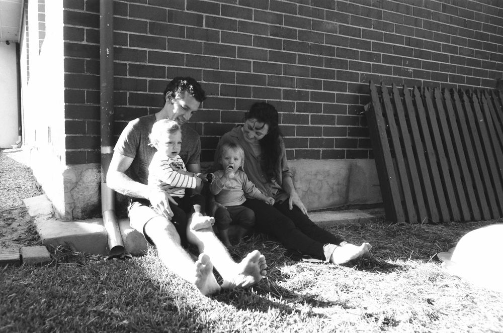 Candid family photos in the backyard of a Perth home, capturing the joy of twins and their parents.