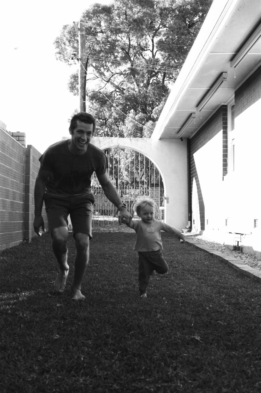 Candid backyard moments during an in-home family shoot in Perth, capturing playful energy of twins