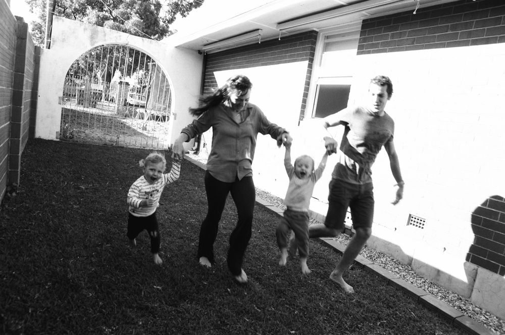 Candid family photos in the backyard of a Perth home, capturing the joy of twins and their parents.