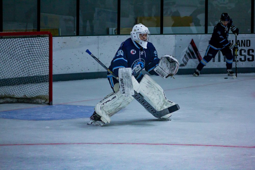 Peoria Mustangs Goalie Kason Yamada in blue uniform takes defensive stance during warmups.
