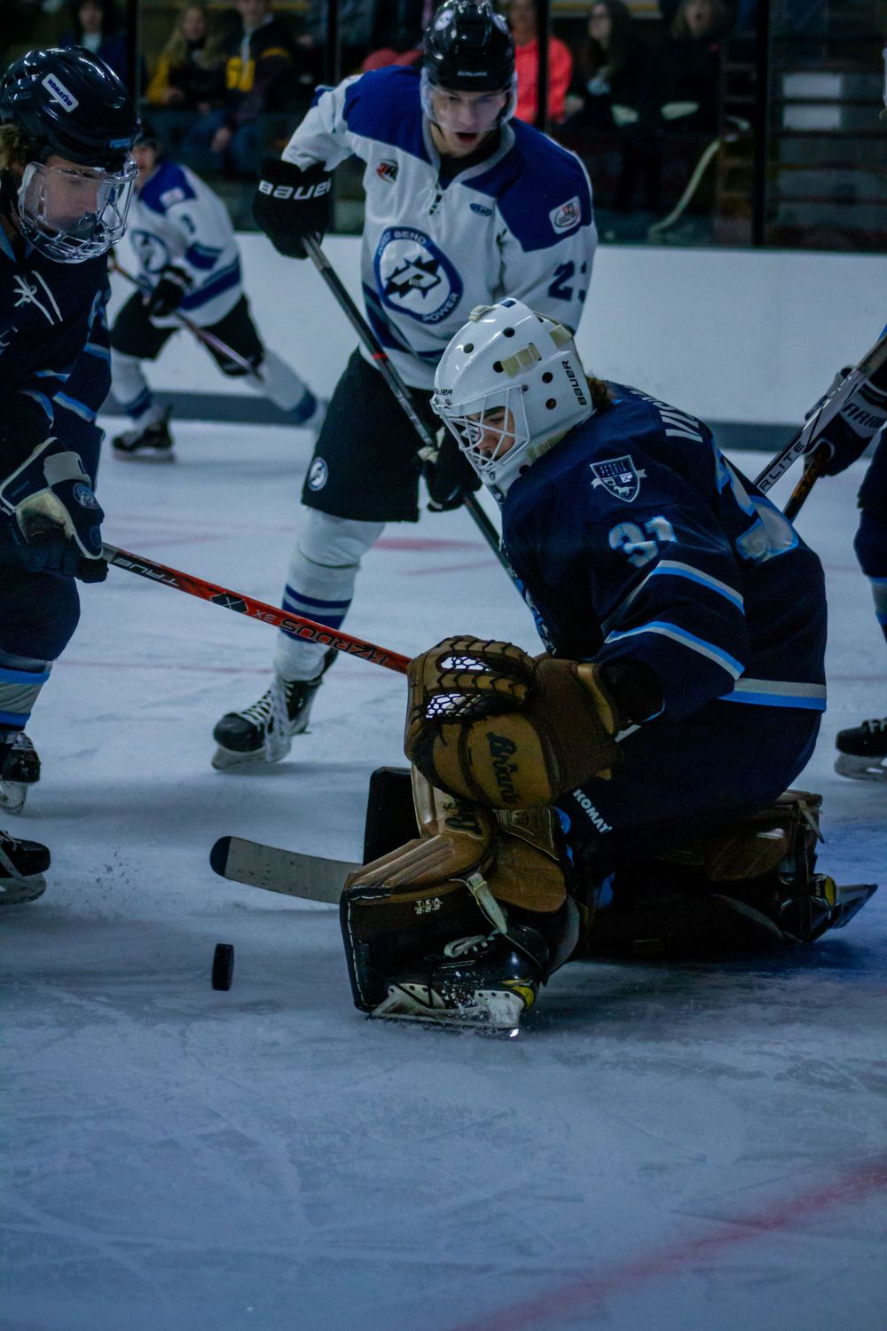Peoria Mustangs Goalie Travis Visvadra makes a save during intense hockey game action with players battling around the crease.