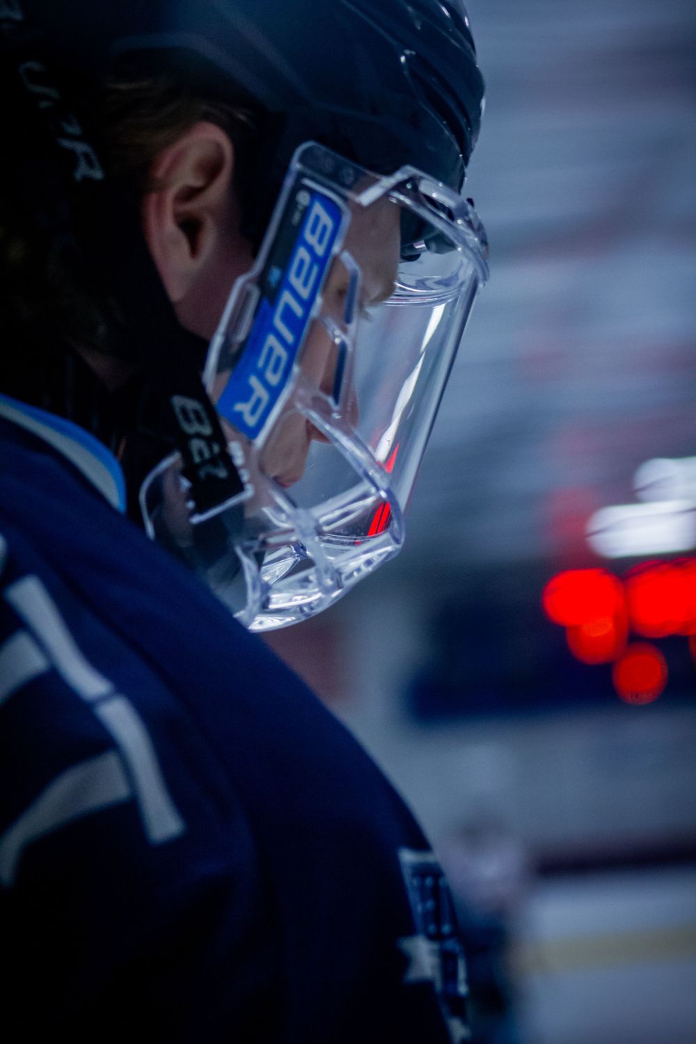 Close-up of a hockey player wearing a blue jersey and clear Bauer visor during a game. In Affton, Missouri.
