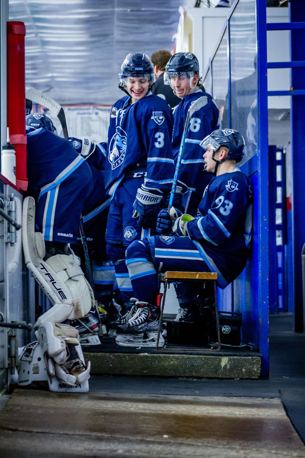 Peoria Mustangs Hockey players in blue jerseys sitting on bench towards the end of a game. In Affton, Missouri