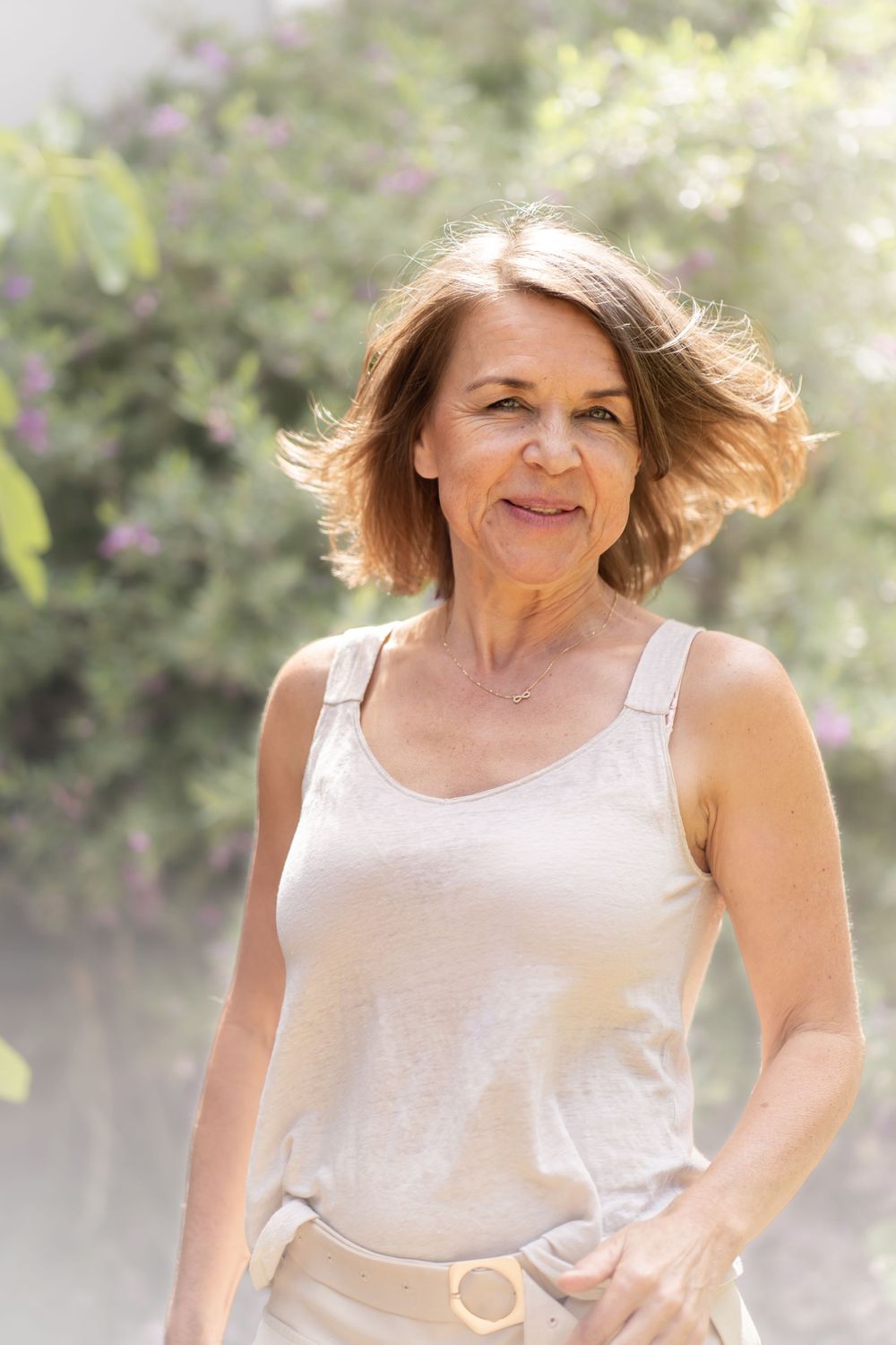 A bright outdoor portrait showing natural joy and movement in a garden setting.