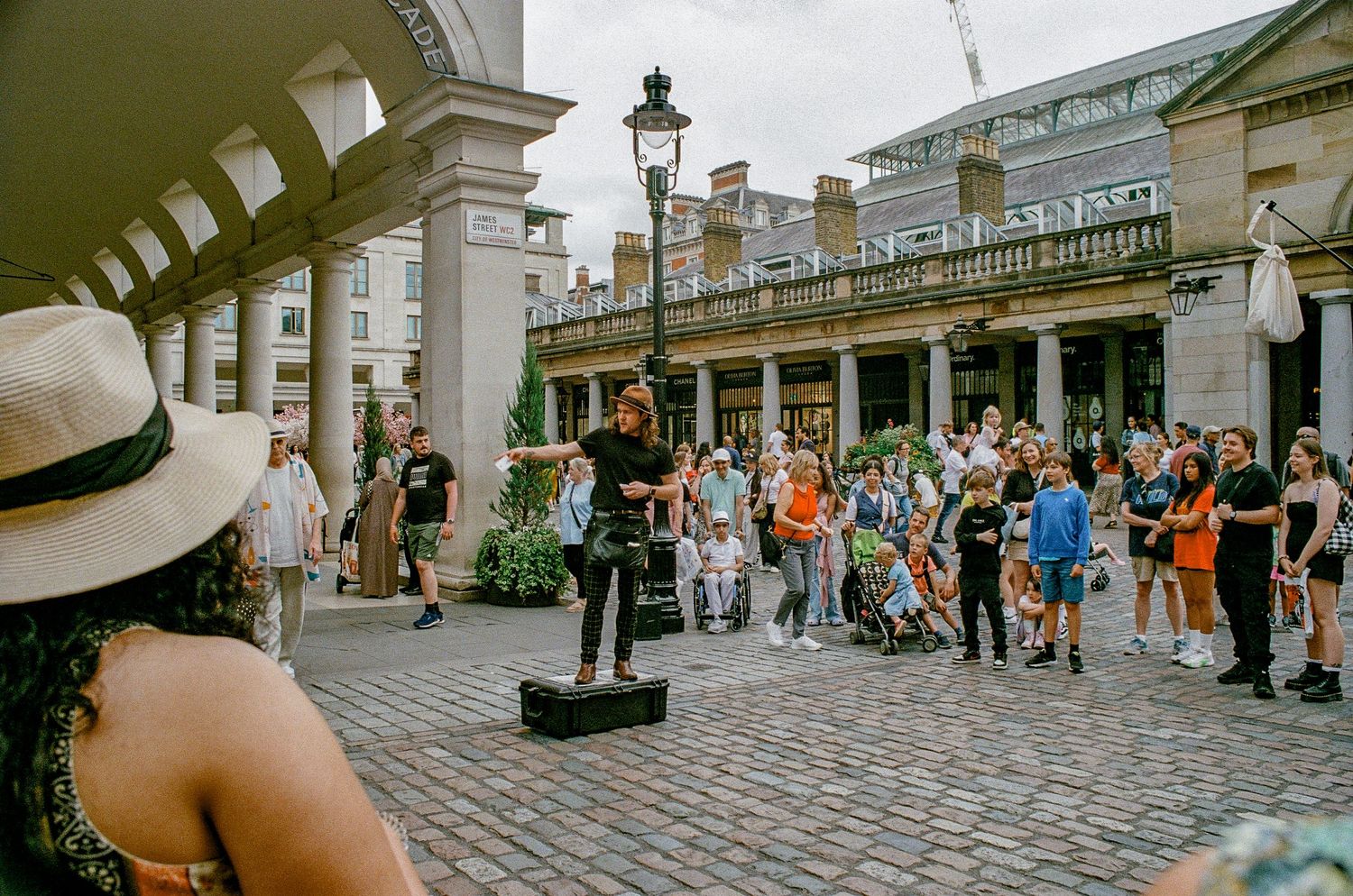 Street performer entertains crowd at Covent Garden Market in London.