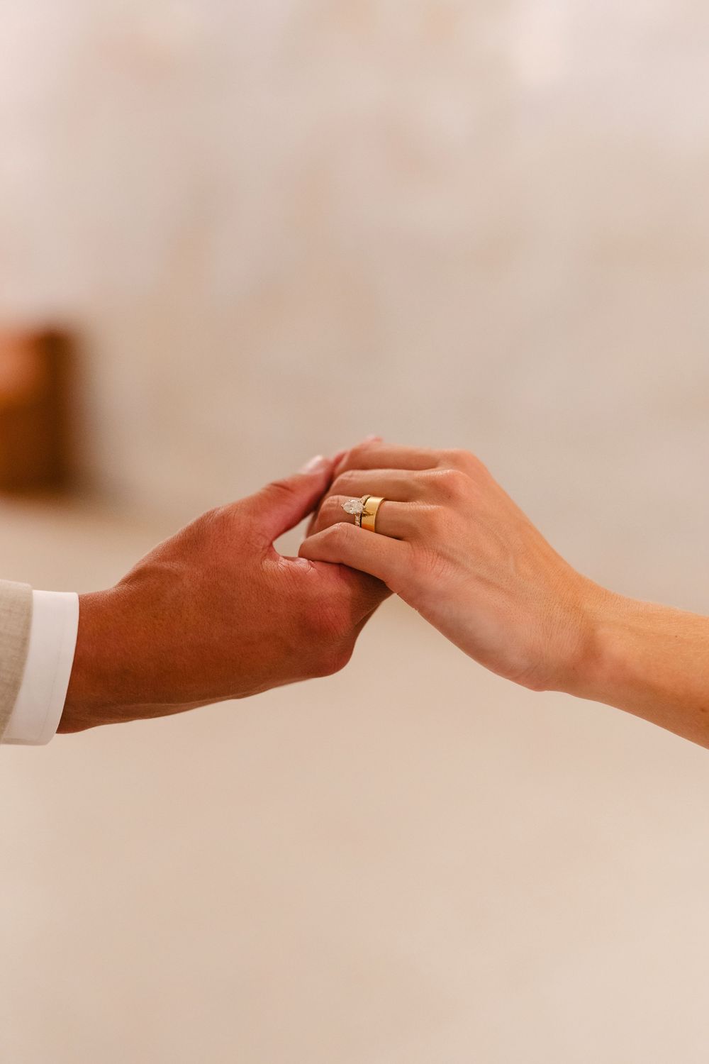 A sequence of hands reaching out and touching each other in a soft, blurred romantic setting.