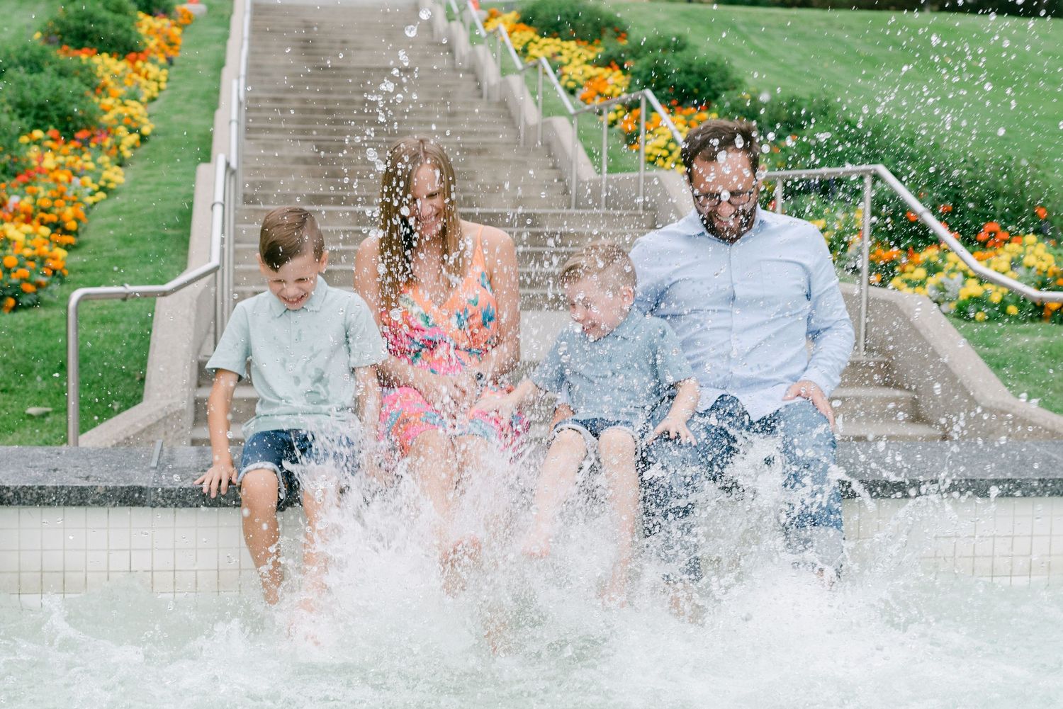 young family splashing in a fountain