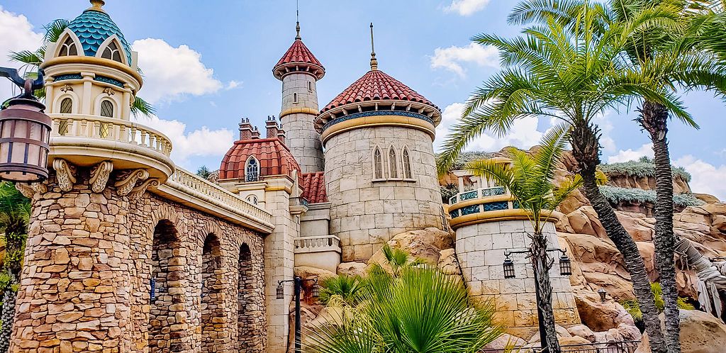 Architectural details of Prince Eric's Castle with stone arches and ornate turrets at Disney's Magic Kingdom theme park.