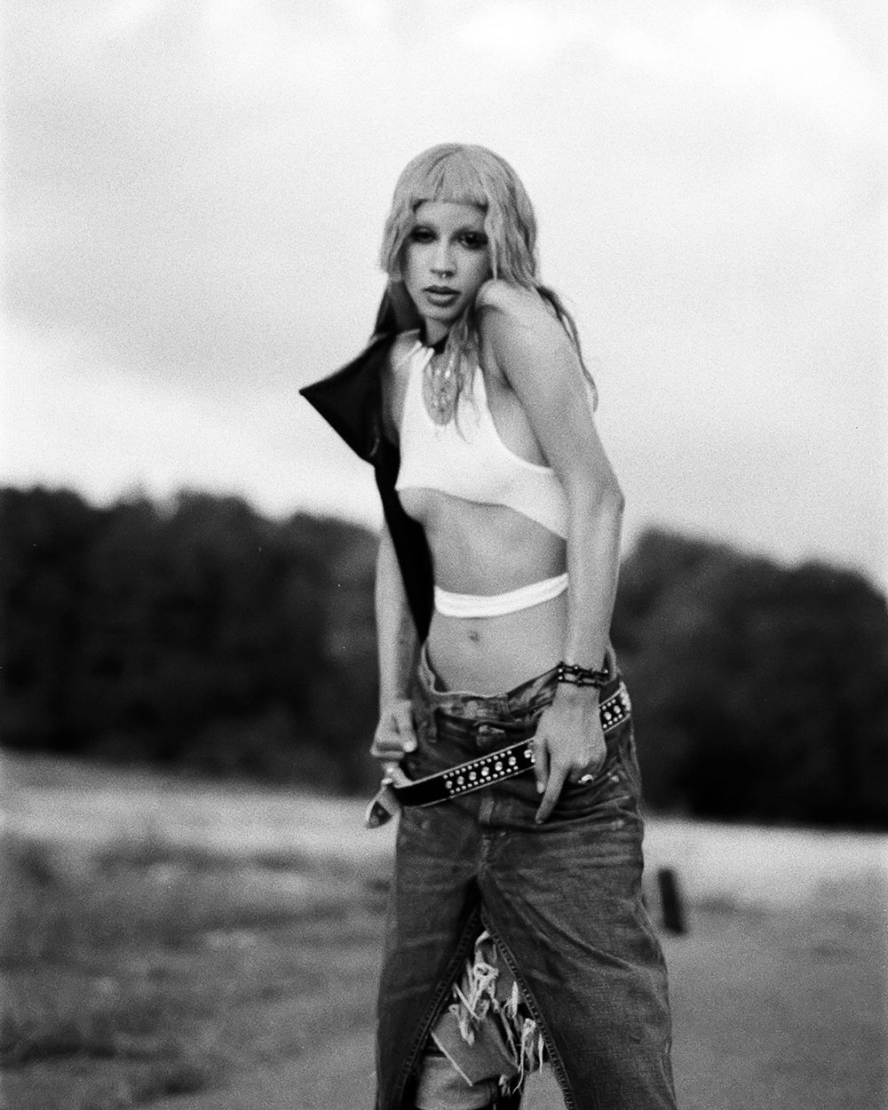 Black and white outdoor fashion photo with edgy street style aesthetic.