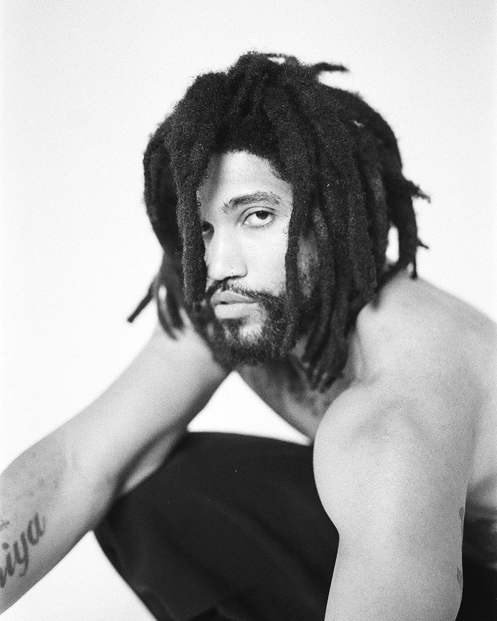 Black and white portrait showcasing dreadlocks and artistic expression.