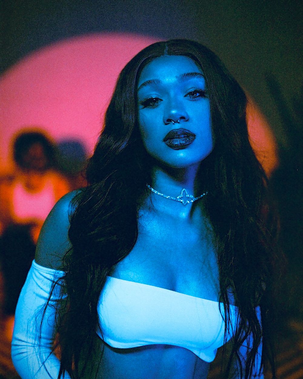 Artistic portrait with neon pink and blue lighting effects.