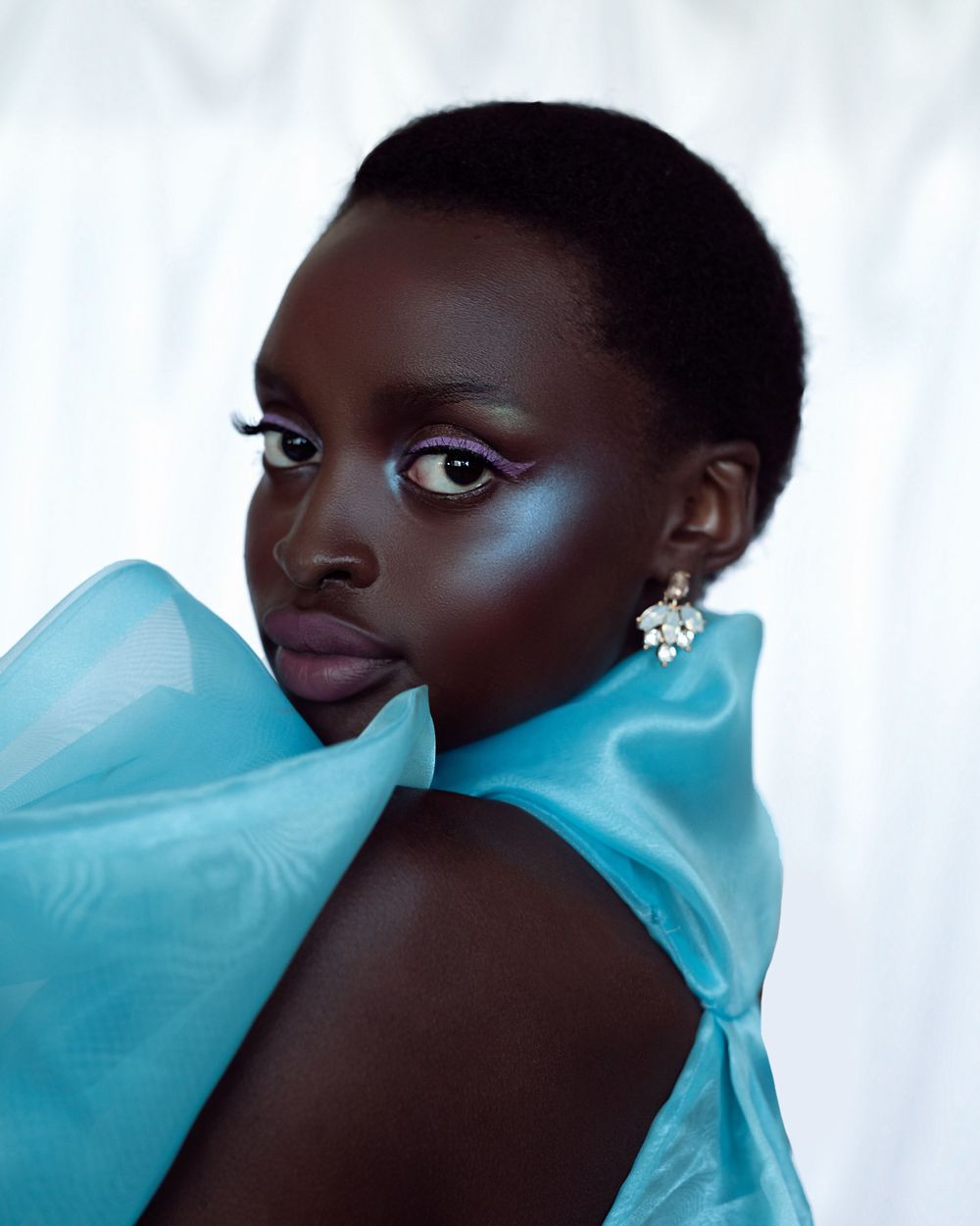Elegant portrait with turquoise fabric and diamond earrings.