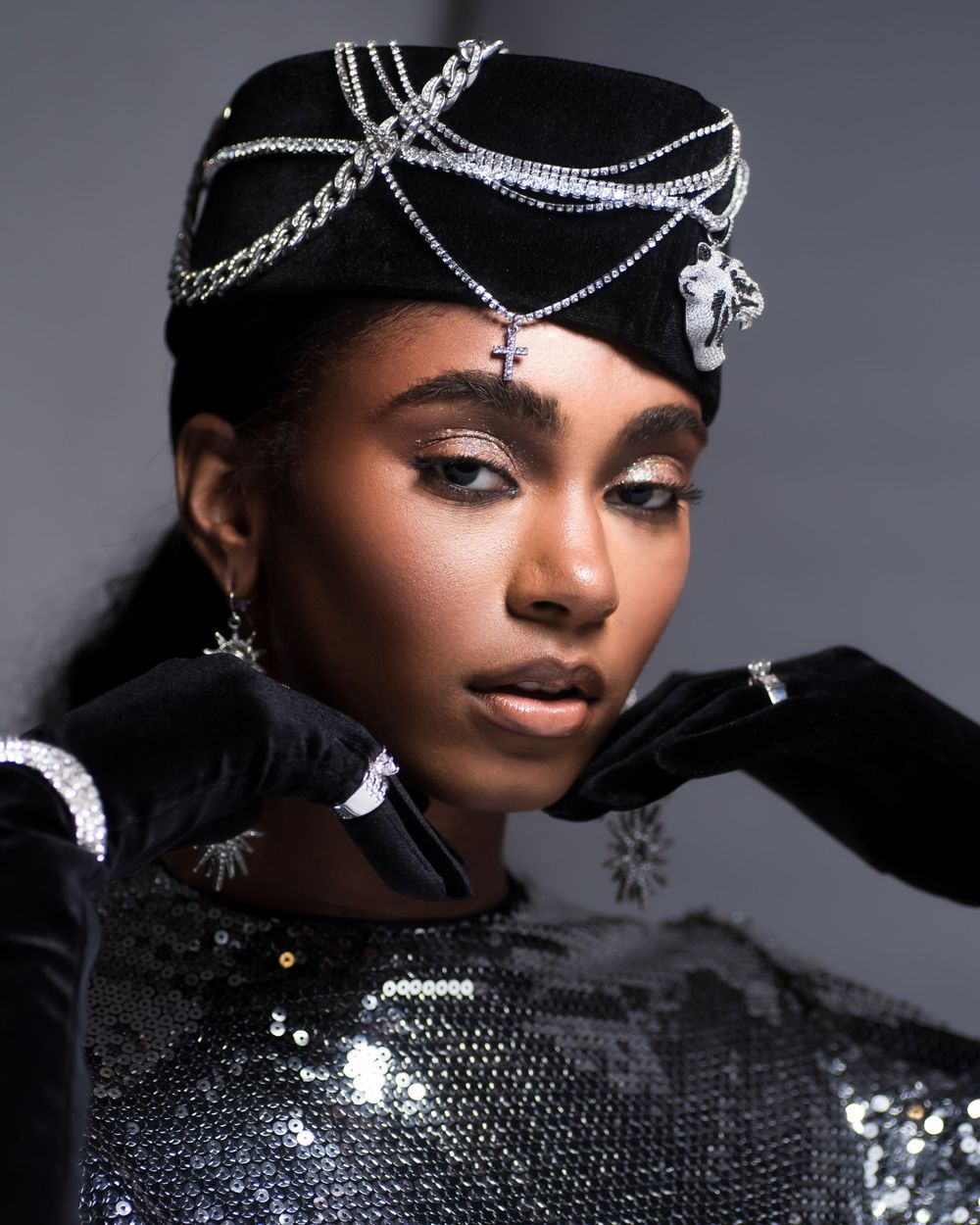 High fashion portrait with silver chain headpiece and black sequined outfit.