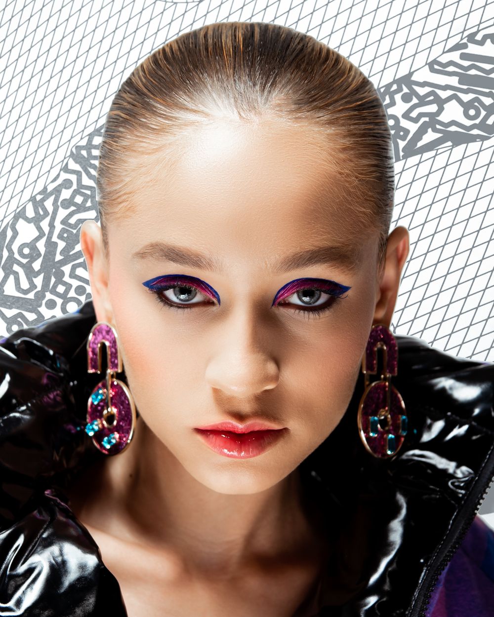 Fashion beauty portrait with purple eye makeup and statement earrings.
