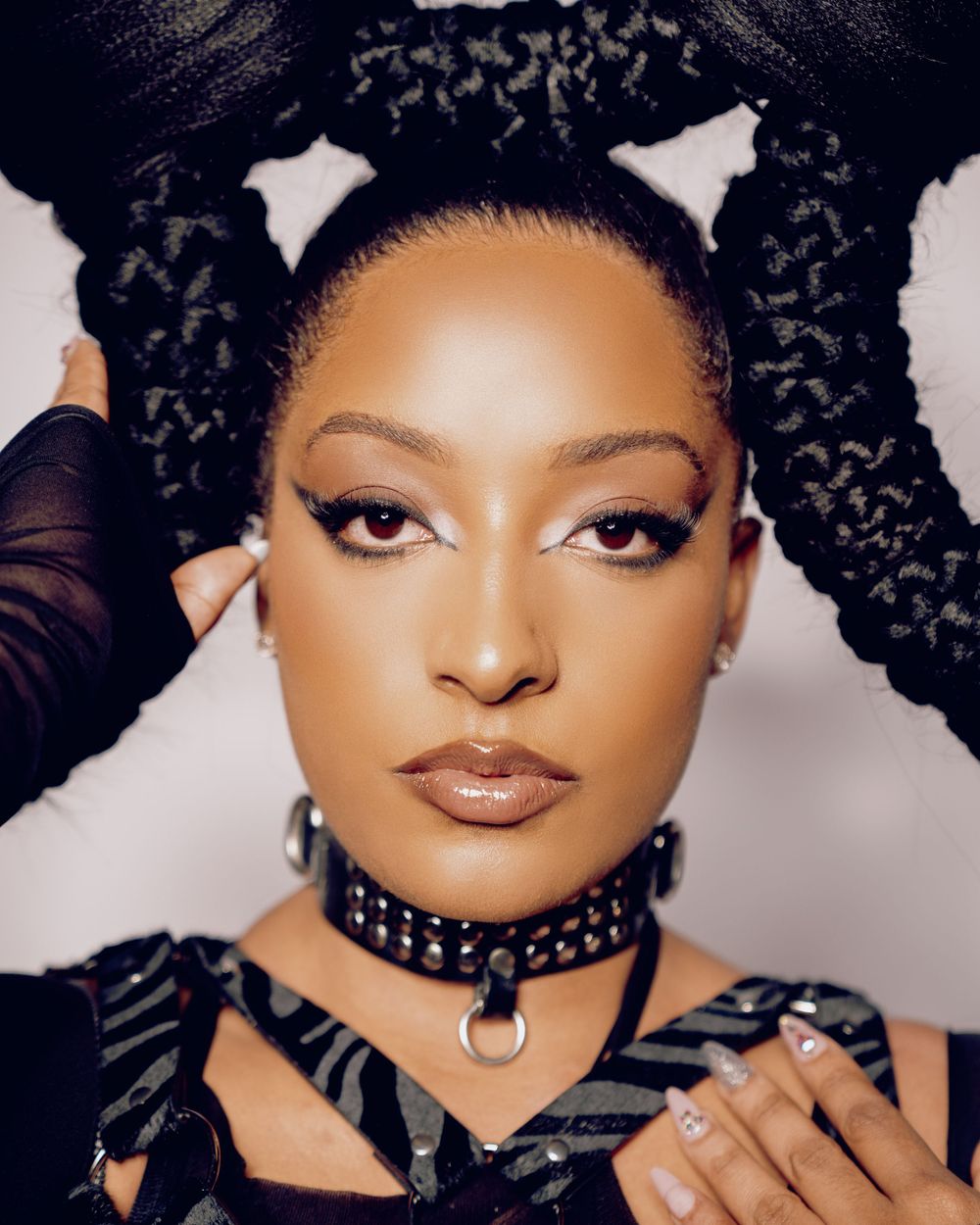 Dramatic portrait with textured hair and studded choker necklace.