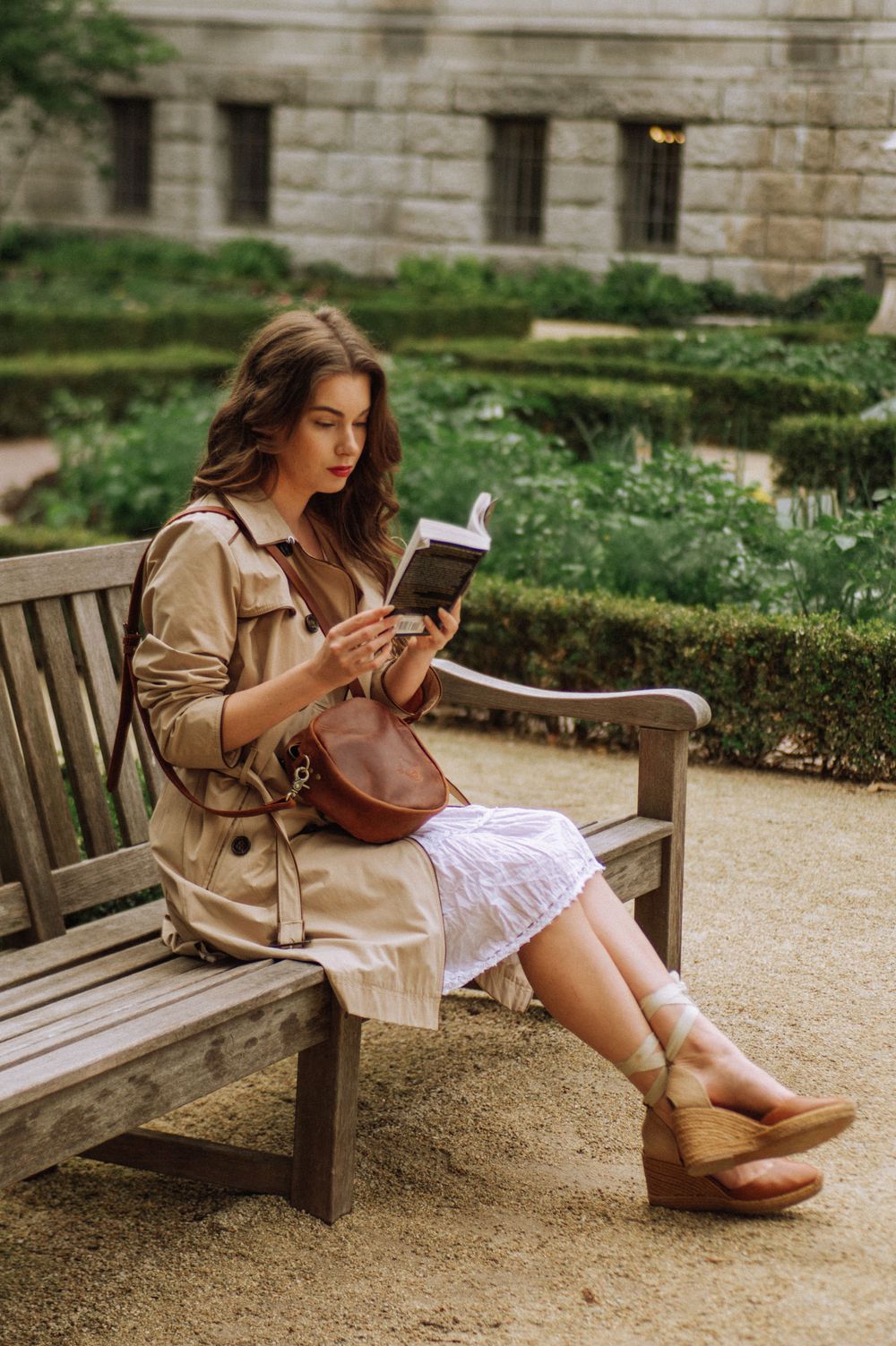 Casual outdoor portrait session on a wooden bench near a stone building.