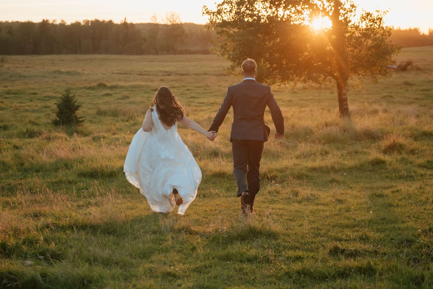 A romantic couple embraces in a forest setting with warm autumn colors and golden foliage in the background.