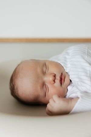 close up of newborn boys face sleeping while laying on changing table