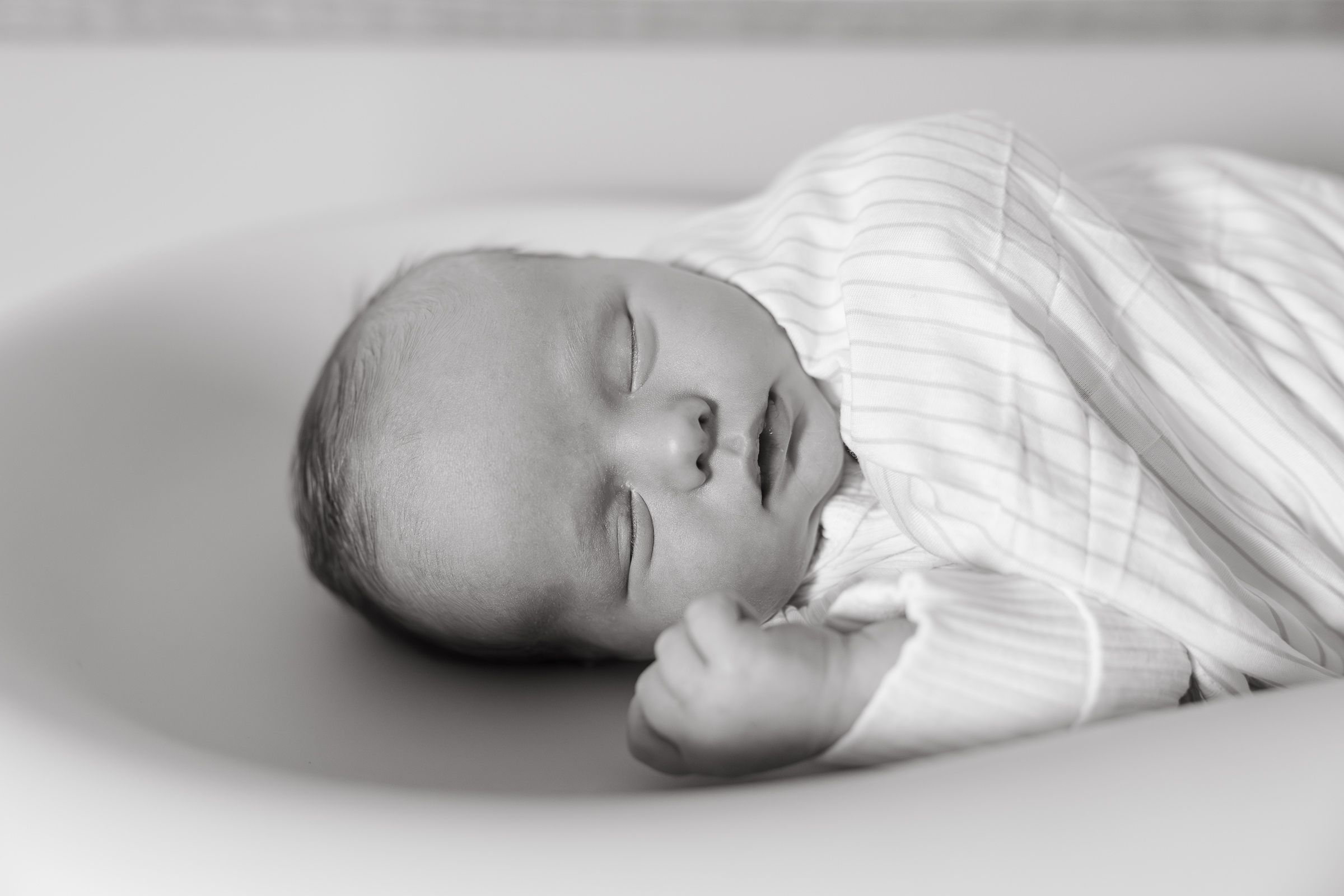 close up photo of sleeping newborn baby boy in black and white