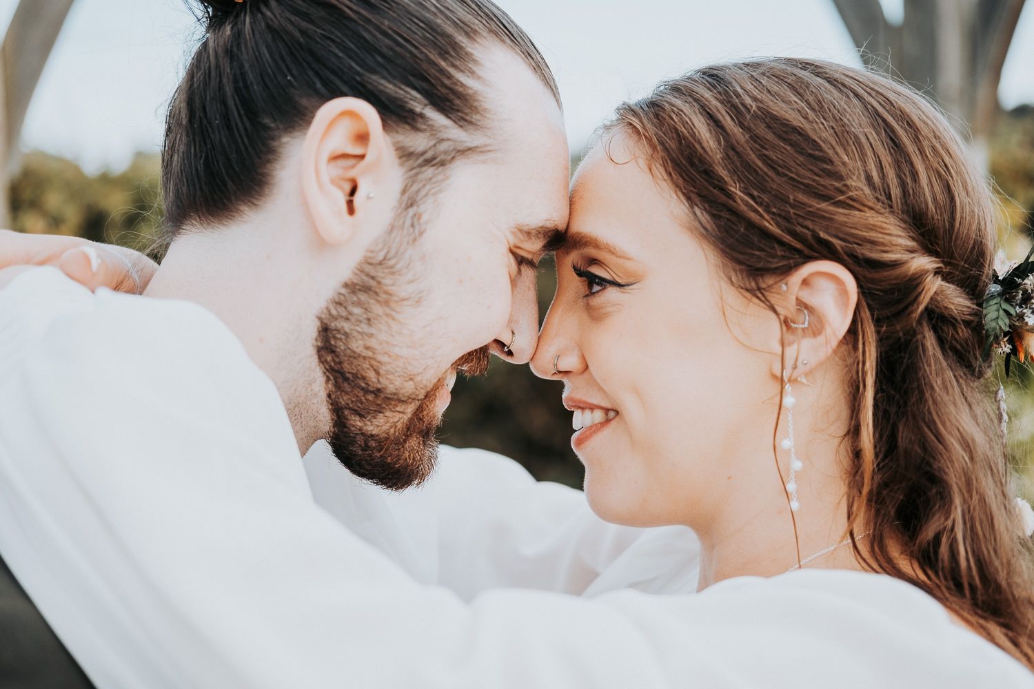 Intimate wedding moment captured in soft natural lighting outdoors.