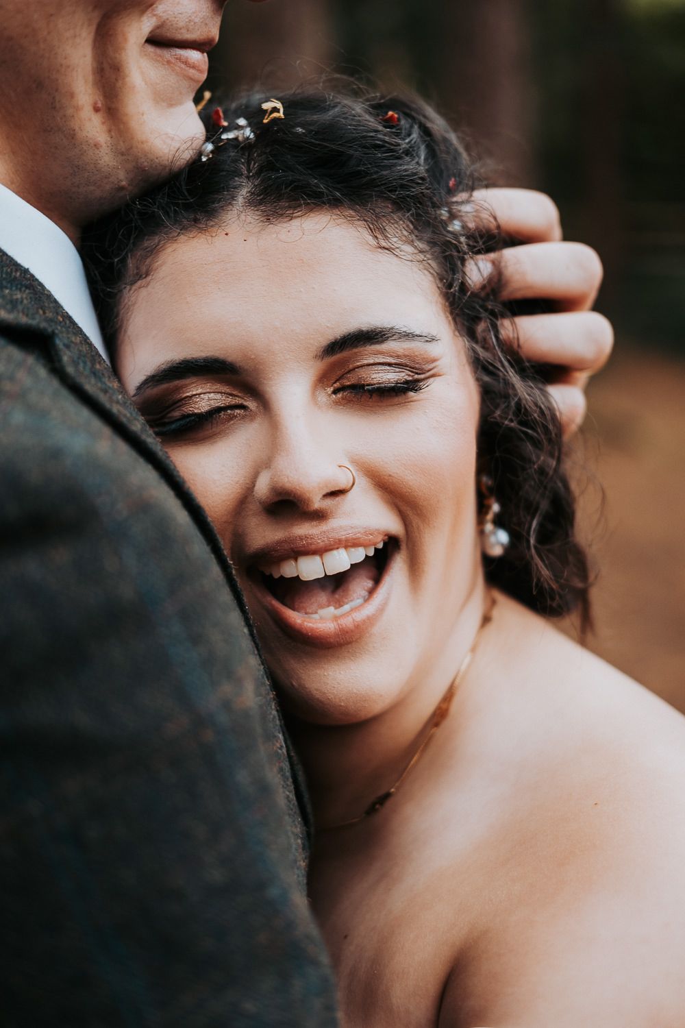 Close-up candid wedding portrait showing joyful laughter during an intimate moment.