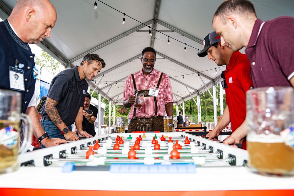 People gathered under a tent sampling and judging drinks at a beverage tasting competition event.