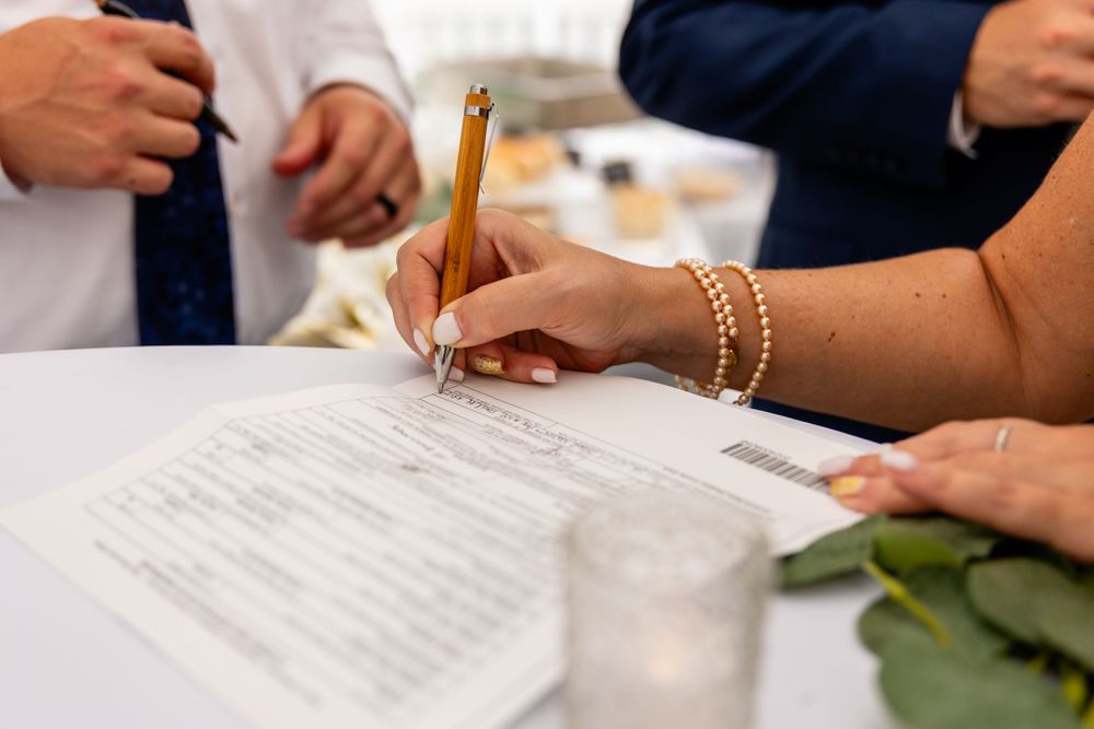 Signing the marriage license at backyard garden wedding in Omaha, Nebraska. - BrightSide Photography