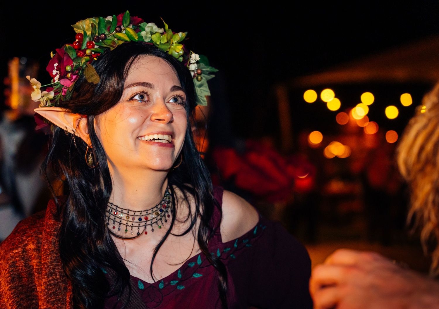 Portrait of a woman in an elf costume with a flower crown, captured by an event photographer. Elfia vivitu