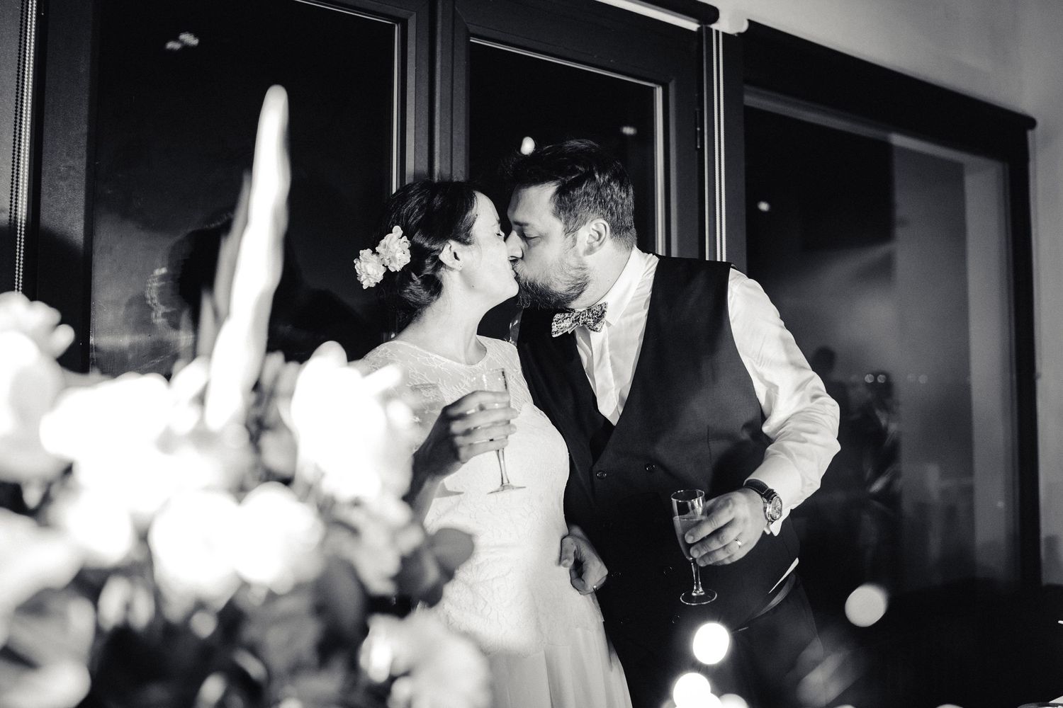 Black and white wedding photo capturing an intimate moment during reception.