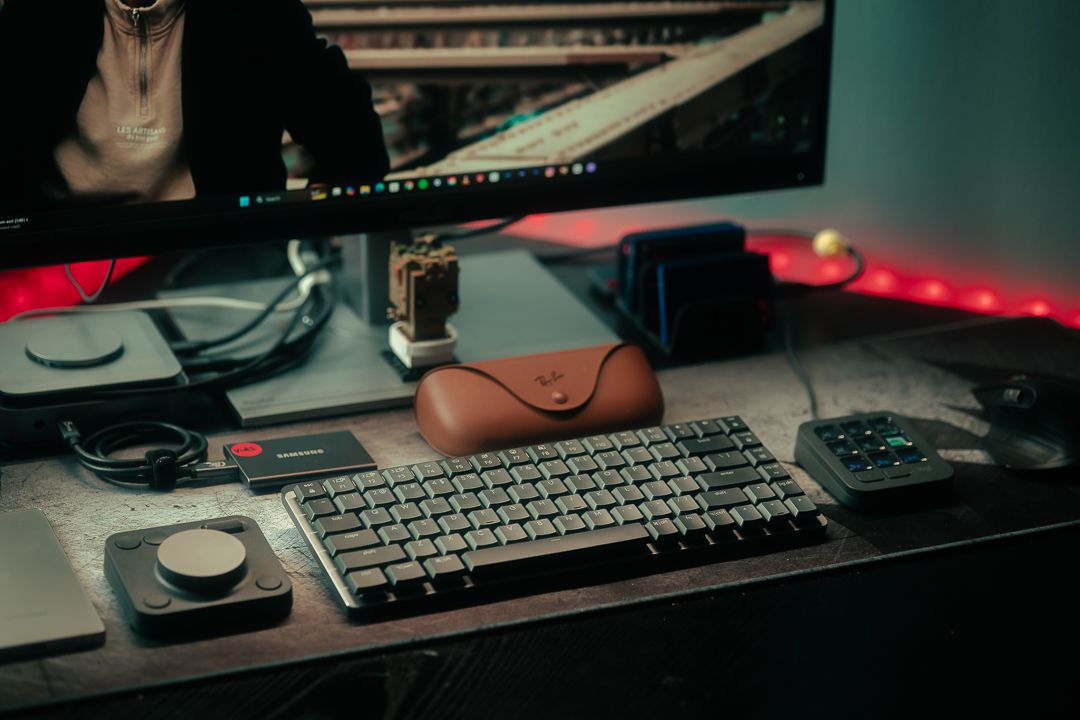 Effortless workflow at Mannyportraits studio – cinematic photography desk setup with Ray-Ban case, keyboard, and creative workspace in Miami