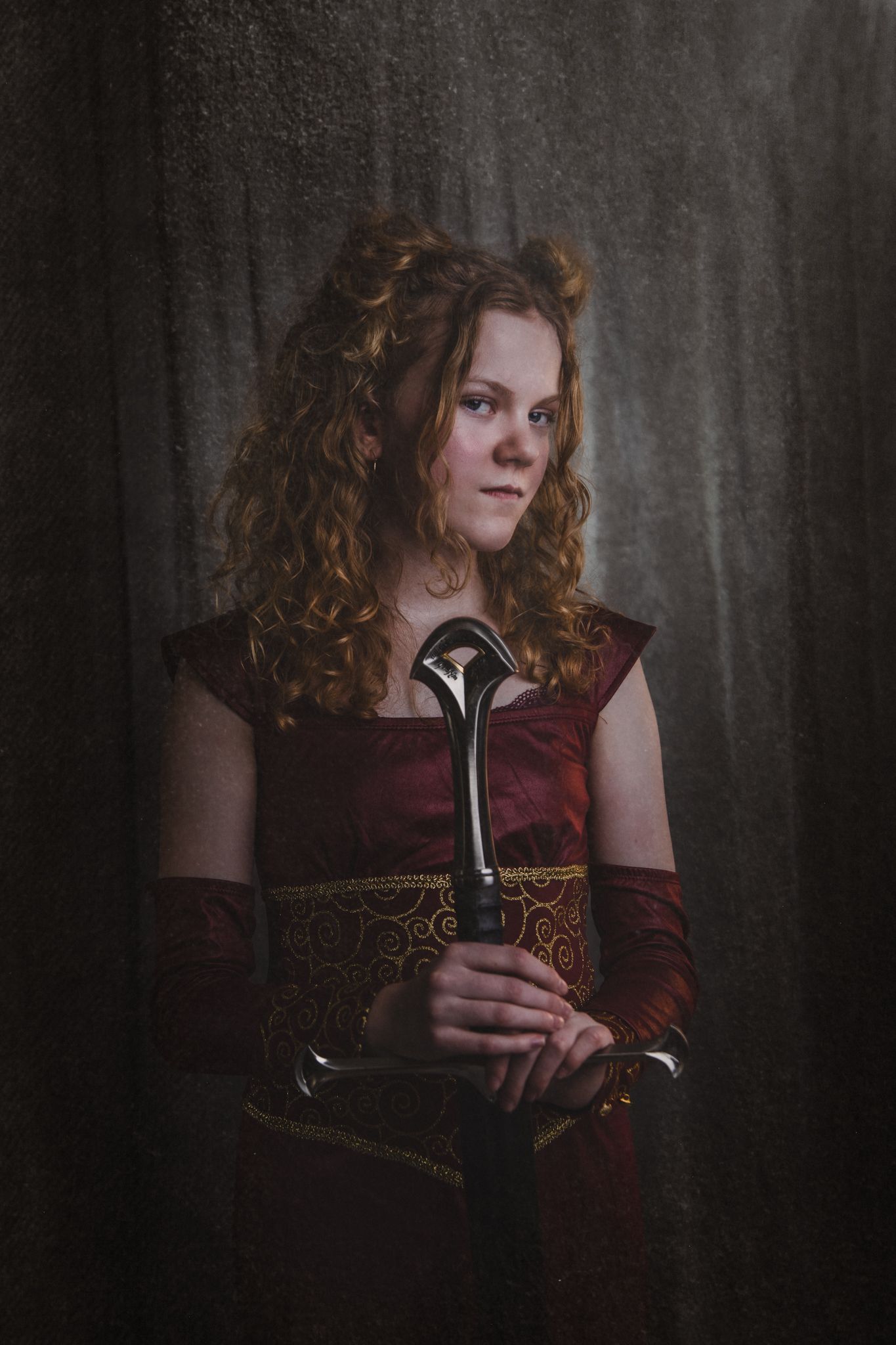 A medieval-styled portrait of someone holding a staff in burgundy velvet attire.