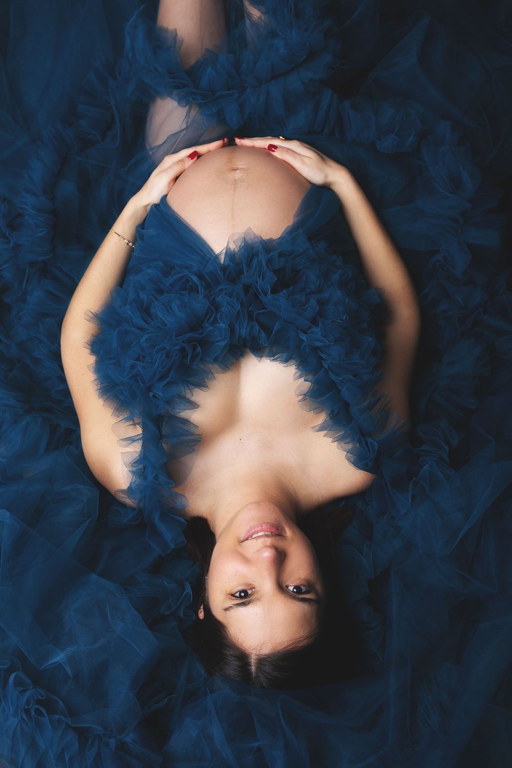 Portrait series of a person lying on blue fabric with their hair spread out in different angles and poses.