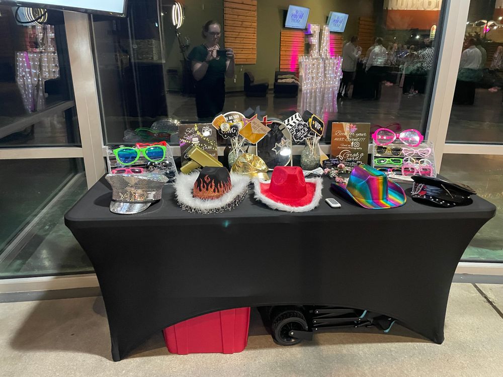 A table display of colorful and decorative hats including festive holiday designs laid out on a black tablecloth.