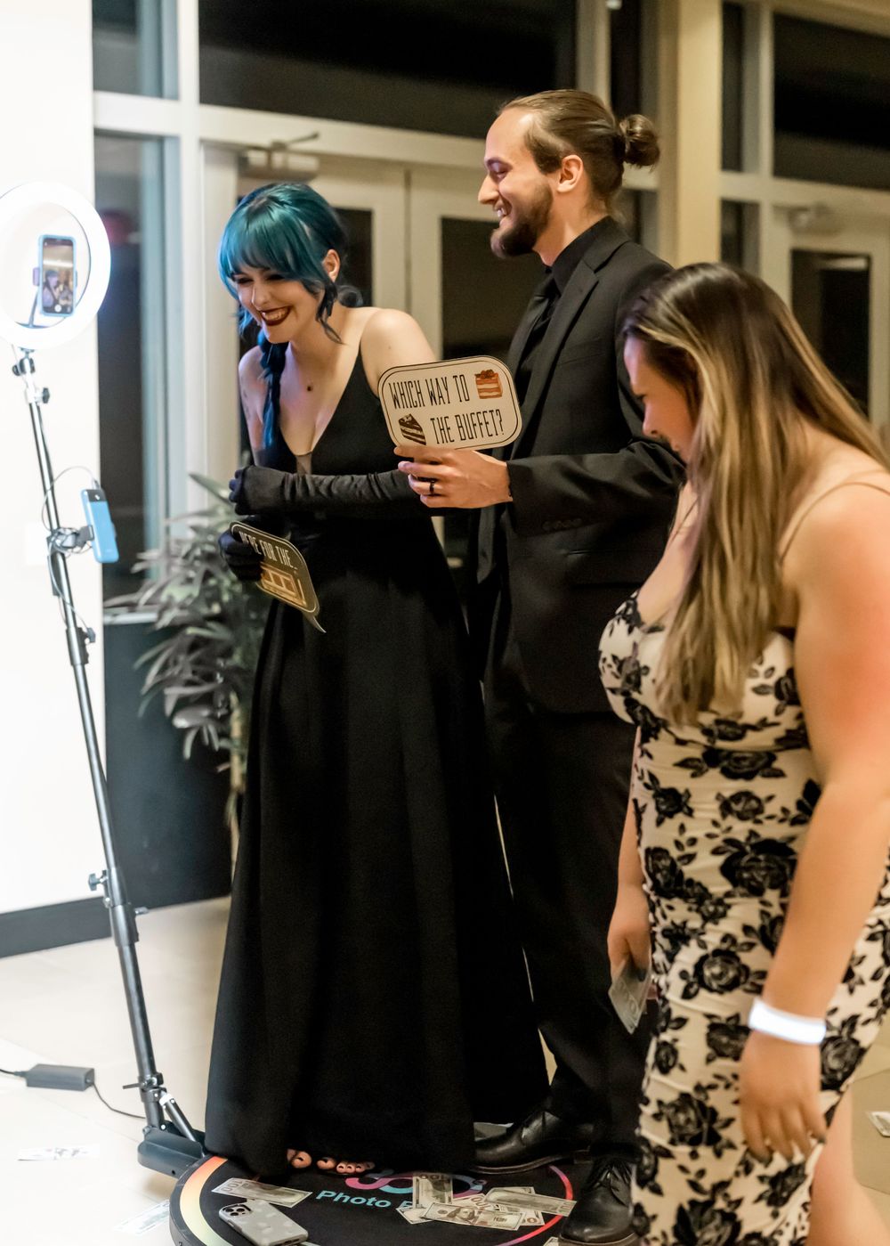 Three people share a laugh while reading scripts during a theatrical performance rehearsal.