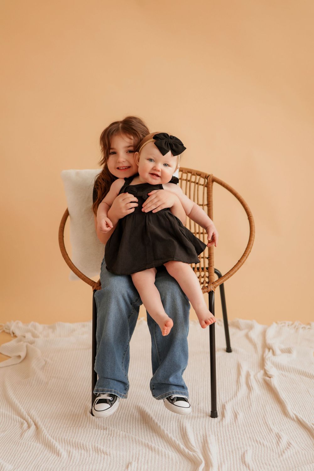 A heartwarming moment captured on a wooden chair with a white blanket.