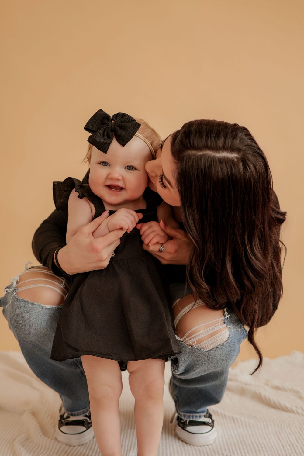 Sweet candid moments captured during a family photo session on a white blanket.