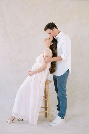 Romantic dance sequence of couple in white and denim against light backdrop showing graceful dips and movements.