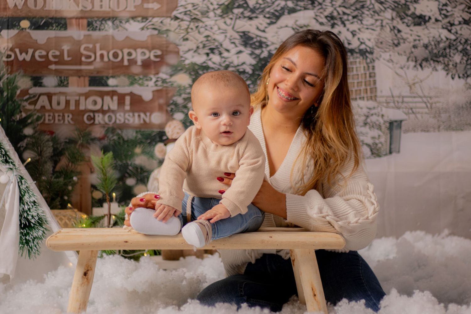 Cozy winter photo session setup with red and white candy cane decorations and snowy backdrop.