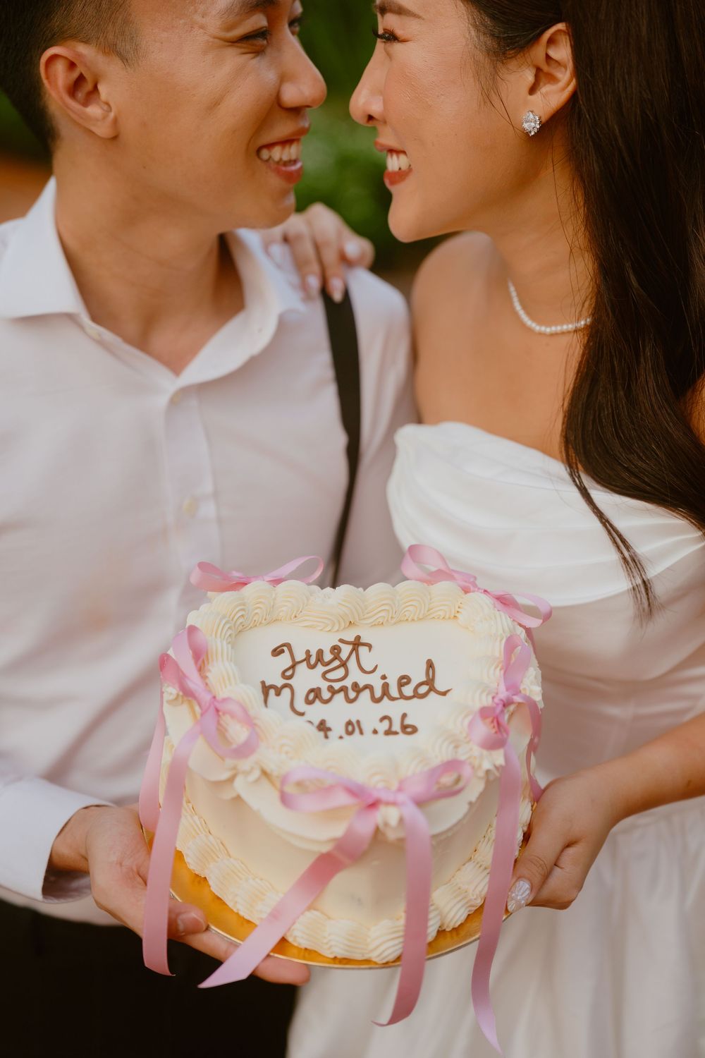 A wedding cake decorated with pink ribbons and 'Just Married' text is displayed in multiple romantic shots.