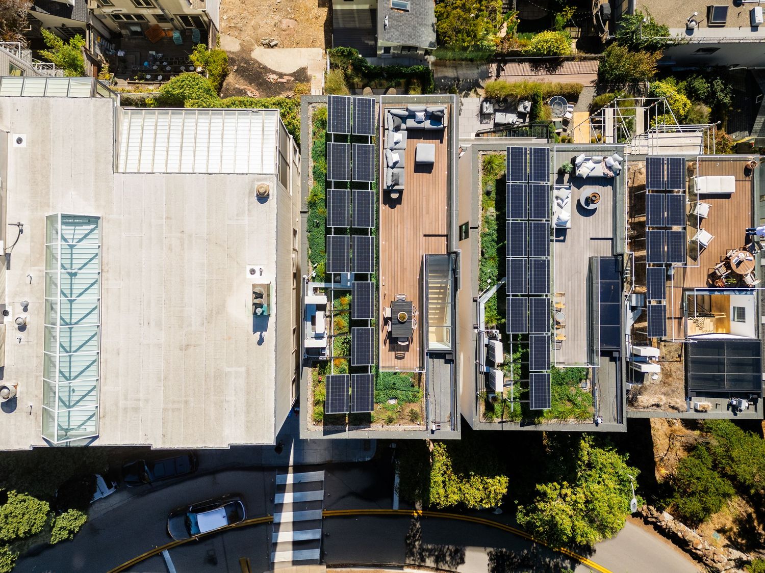 Aerial view of mobile homes and RVs parked in a residential community with trees and paved roads.
