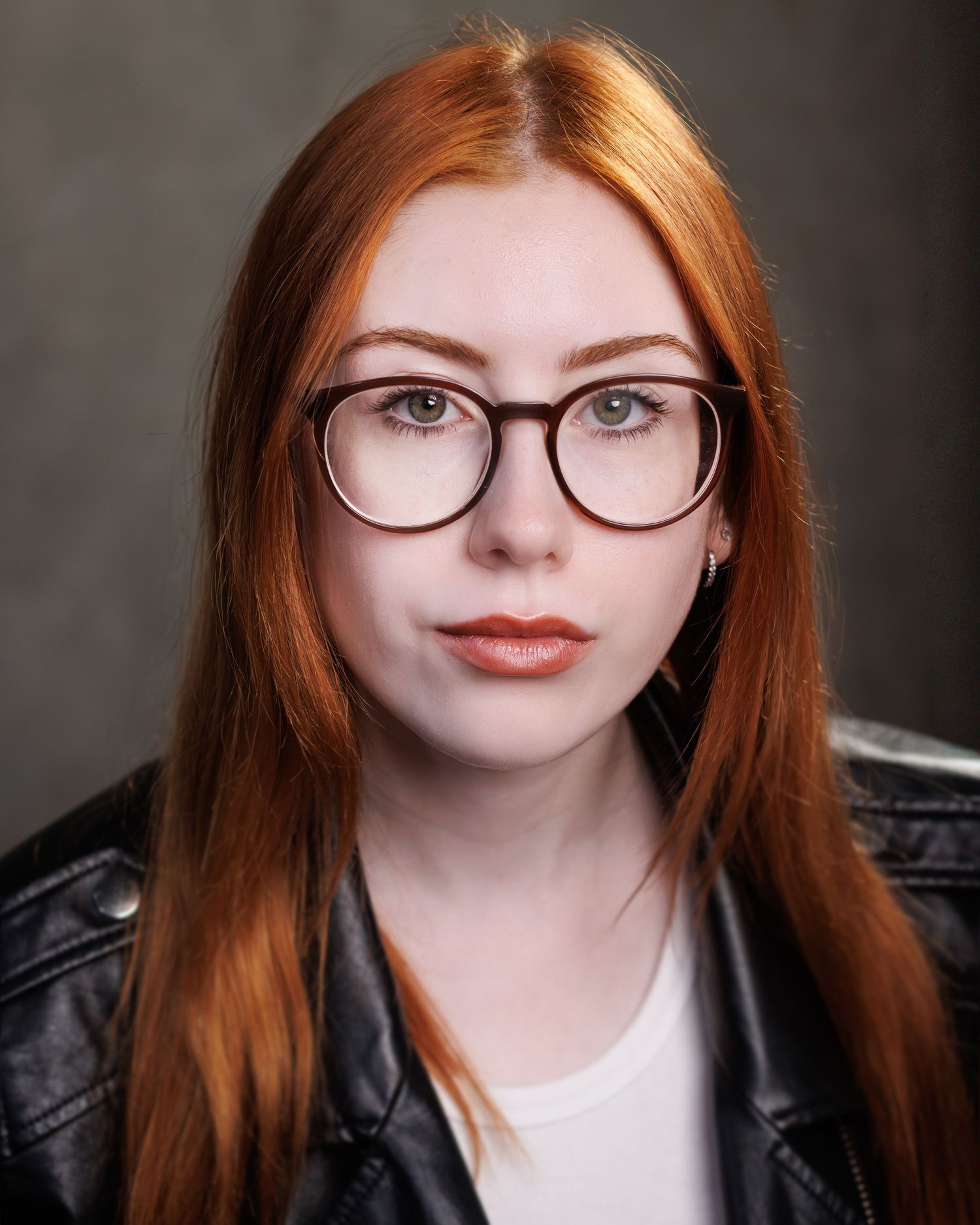 Portrait series showing a person with red hair and glasses in different poses against a dark background.