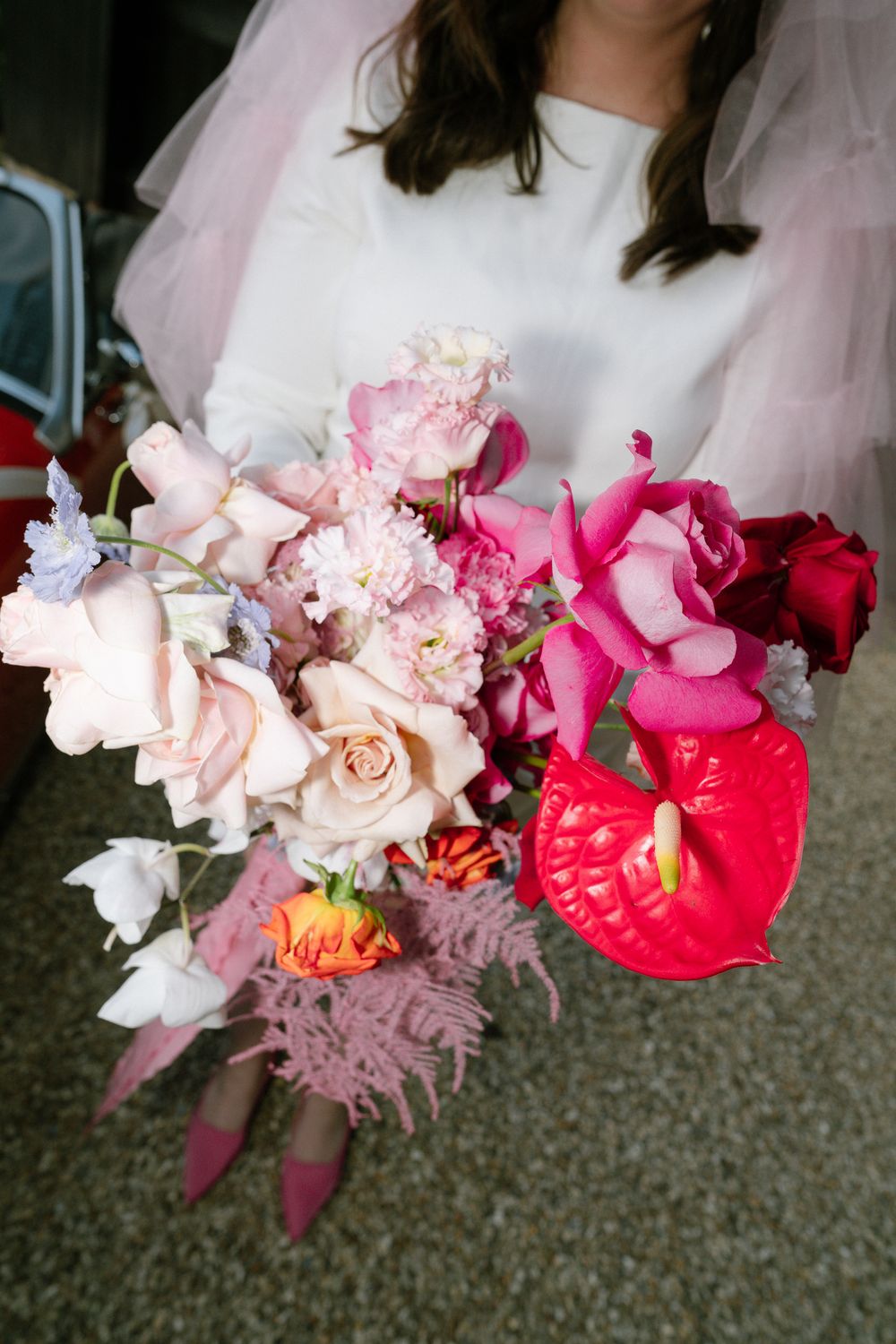A sequence of four pink and coral floral bouquets with roses and other blooms arranged against a dark carpet background.