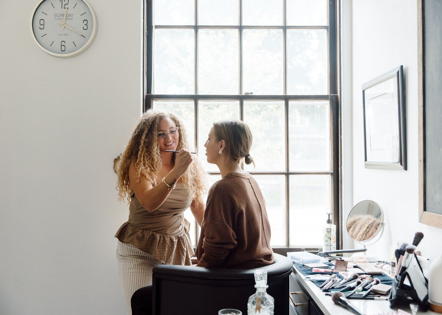 Two people having an intimate conversation by a bright window in an office setting.