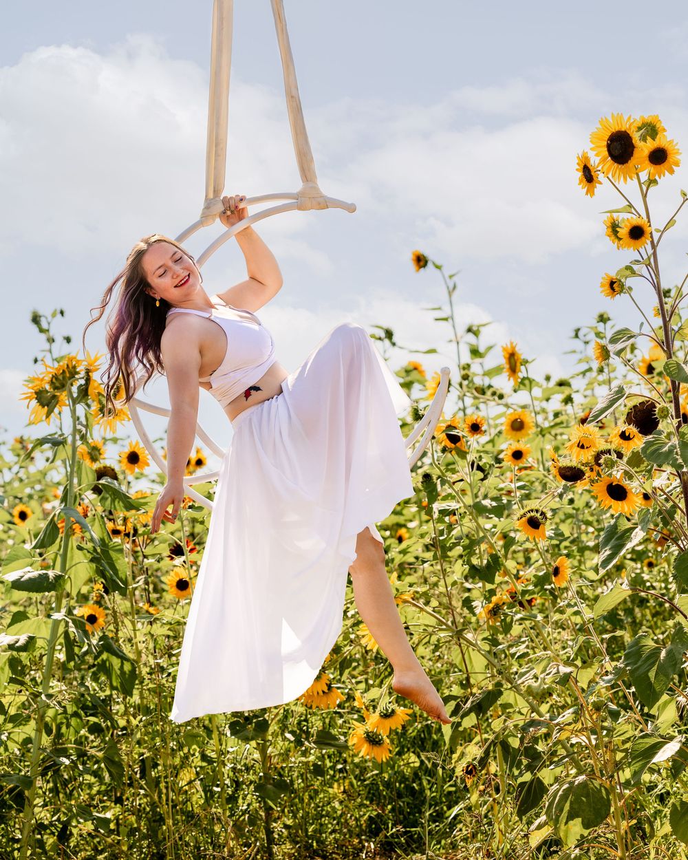 Aerialist on moon lyra in a sunflower farm in located in Northern Utah.